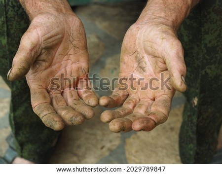 The calloused hands of an elderly man doing agricultural manual labor. Labor protection and agriculture. Social protection of handymen.