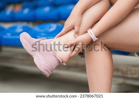 Callus on the heel while running, plantar fasciitis, heel spur, foot pain, woman suffering from feet ache on a sports ground after workout, podiatry concept