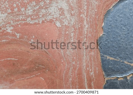 Calm abstract background texture showing natural red and blue weathered rock surface. rough detail pattern and geologic strata create an interesting organic visual
