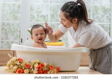 Calm Asian Baby Bathing In Bathtub Enjoy Laughing. Mother Bathing Her Son In Warm Water.Happy Adorable Newborn Infant Smile In Tub Relax And Comfortable Good Moment With Mom. Newborn Baby Care Concept