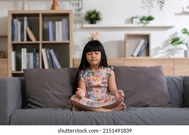 Calm Of Asian Child Cute Making Yoga Meditation With Inhale And Exhale. Sit On Couch For Focusing Mind And Soul. Relaxed With Hand Pleat In Living Room, Indoor Meditating For Peaceful With Yoga.