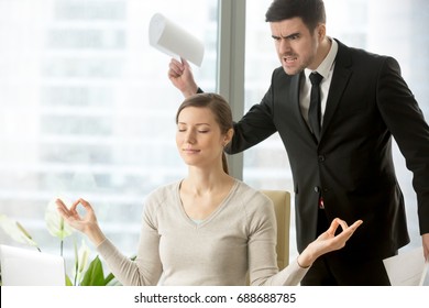 Calm attractive businesswoman practicing yoga at work, meditating in office with eyes closed, ignoring angry bad boss standing behind her back, avoiding negative people, positive thinking, no stress