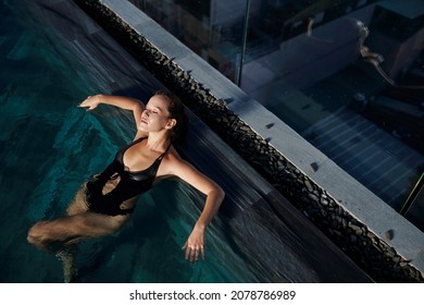 Calm Beautiful Young Woman Relaxing In Swimming Pool At Night, View From Above