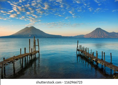 Calm Blue Lake Atitlan Guatemala Morning Sunrise, Tranquil Shore Docks View with Volcanoes in Background - Powered by Shutterstock