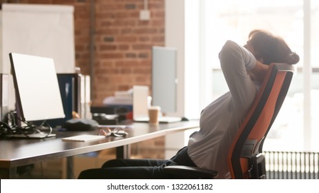 Calm businesswoman office worker holding hands behind head finished computer work at workplace relaxing sitting in ergonomic chair taking break rest feel no stress relief balance having healthy nap