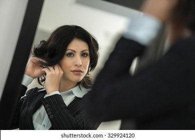 Calm Caucasian Young Woman With Medium Black Hair In Business Formal Outfit Using Full Length Mirror