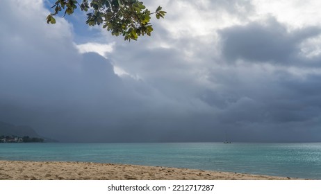 A calm cloudy day on a tropical island. Boats are visible in the turquoise ocean. A green branch hung over the sandy beach. Seychelles. Mahe. Beau Vallon - Shutterstock ID 2212717287
