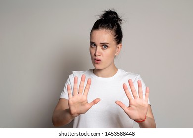 Calm, Confident Young Woman Put His Palms Forward As Protection, Calming Someone Down And Looking At The Camera. Isolated On White Background. Close-up.