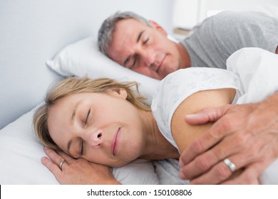 Calm Couple Sleeping And Spooning In Bed In Bedroom At Home