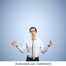 Calm Down Concept With Man In White Shirt In A Zen Pose Isolated On Light Blue Wall Background With Empty Place For Your Text Or Logo, Mock Up