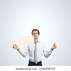 Calm Down Concept With Man In White Shirt In A Zen Pose Isolated On Light Grey Wall Background With Empty Place For Your Text Or Logo, Mock Up