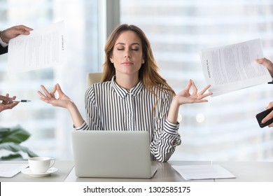 Calm female executive meditating taking break at work for mental balance, mindful businesswoman feeling relief and no stress doing yoga at work ignoring avoiding stressful job and paperwork in office - Shutterstock ID 1302585175