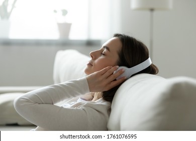 Calm female resting leaned on comfy couch in living room spend free time at home closed eyes enjoy music listening favourite song through wireless modern headphones. Pastime weekend relaxation concept - Shutterstock ID 1761076595