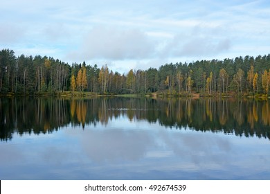 Calm forest lake with reflections, called Chertovo lake. Russia, Saint-Petersburg region. Golden autumn