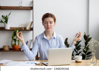 Calm healthy business woman meditate taking break relaxing at office desk feeling balance zen managing reducing work stress relief, mindful employee doing yoga at workplace, peace of mind concept - Powered by Shutterstock