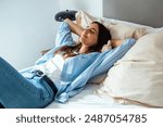 Calm millennial woman relaxing on soft comfortable bed meditating or having daytime nap, carefree lazy girl breathing fresh air enjoying no stress free peaceful weekend morning resting on couch