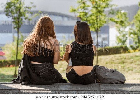 A calm moment of a couple of young friends of generation Z on a city bench, their closeness, personifying the closeness and kinship of souls, against the backdrop of a city street