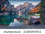 Calm morning view of Braies (Pragser Wildsee) lake with boats and fishing dock. Stunning summer sunrise in Fanes-Sennes-Braies national park, Dolomiti Alps, South Tyrol, Italy, Europe.
