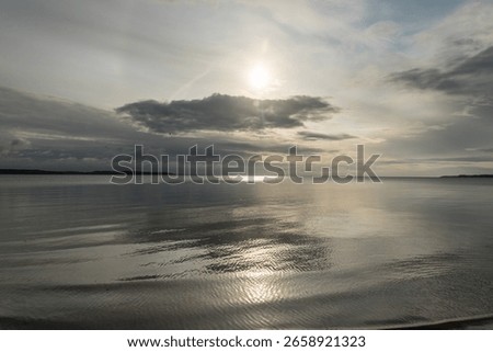 calm ocean with dramatic cloud at sunrise with sun reflecting
