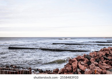 Calm Ocean Waves Gently Lap Against a Rocky Jetty at Dawn Near a Serene Coastline. - Powered by Shutterstock