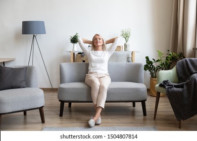 Calm Older Woman Relaxing On Comfortable Sofa At Home, Happy Mature Female With Hands Behind Head Enjoying Weekend, Stretching On Couch, Resting And Daydreaming, Leaning Back, No Stress Concept