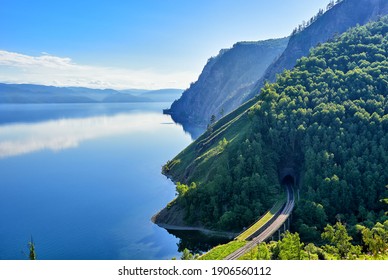 Calm on Lake Baikal. Large-scale top view of Lake Baikal and the section of the Circum-Baikal Railway at the Irkutsk portal of tunnel No. 33. In the background the mountains of Khamar-Daban - Powered by Shutterstock