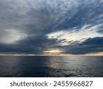 Calm Open Ocean with Sun Breaking through the Clouds. North Pacific Ocean Sunset Scene