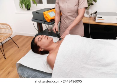 Calm patient undergoing neck electrotherapy by attentive therapist. - Powered by Shutterstock