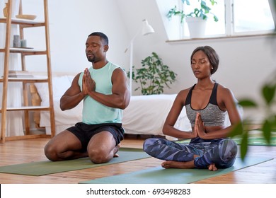 Calm relaxed couple meditating at home doing yoga relaxation