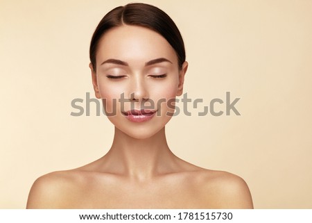 Calm and relaxed.  Healthy sleeping. Beautiful young woman with closed eyes against beige background.