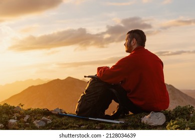 Calm, relaxed hiker man sitting on the mountain contemplating the landscape at sunset after a day of hiking. sports and outdoor activities. healthy life style. - Powered by Shutterstock