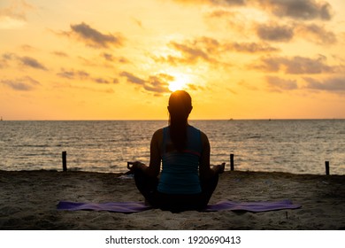 Calm relaxed woman meditating on the beach facing the sun rises.New life for new year concept - Powered by Shutterstock