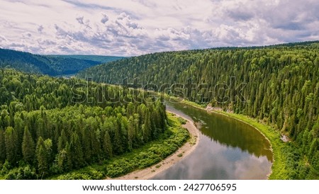Calm river in the mountains. Aerial view of the river, flowing in the Ural Mountains among the impenetrable forest. Russia