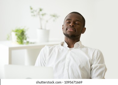 Calm Satisfied African American Businessman Relaxing And Meditating At Workplace, Having Eyes Closed, Person Practicing Emotions Control, Preserving Balance, Managing Stress. Peace, Recovery Concept