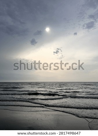 Calm sea beneath dramatic clouds moments before a storm. A coastal scene balancing serenity and anticipation as weather conditions begin to change.