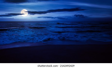 calm sea scenery at night. waves wash empty sandy beach in full moon light. relax and summer vacation concept. warm velvet season weather with clouds on the sky