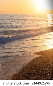 Calm Sea With Sunset Sky And Sun Through The Clouds Over. Sand Beach. Tranquil Seascape. Horizon Over The Water. Vertical Grained Photo, Selective Soft Focus