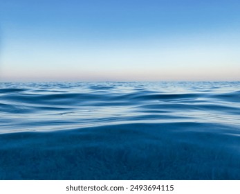 Calm sea under a blue sky at sunrise. waterline. sea water surface