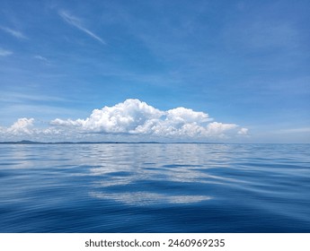 calm sea water surface, with blue sky and cloudscape - Powered by Shutterstock