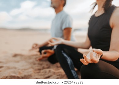 Calm senior caucasian couple in sportswear practice yoga and breathing exercises enjoy peace on beach in morning, outdoor, cropped. Meditating, sports together and lifestyle, focus on hand - Powered by Shutterstock