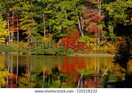 A calm Sherando Lake, Virginia, reflecting bright fall colors