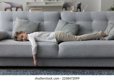 Calm sleepy little kid girl lying on belly, resting on comfortable soft couch with closed eyes, sleeping at daytime. Tired exhausted child taking break in home living room - Shutterstock ID 2258472099