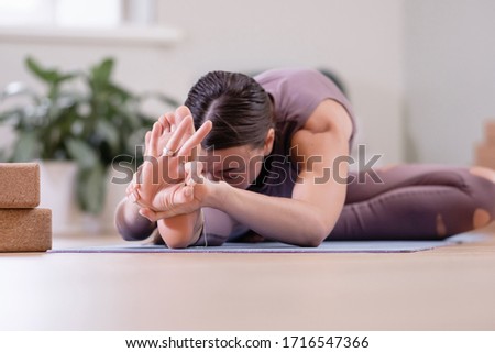 Calm spiritualized young woman yoga instructor meditates in the pose of madha mudra. Concept of the disclosure of energy channels and home yoga sessions. Advertising space