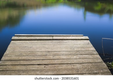 Calm Still Water With Wooden Jetty In The Foreground