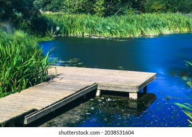 Calm Still Water With Wooden Jetty In The Foreground