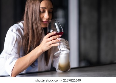 Calm Thoughtful Girl Holds Glass Of Wine In Bionic Arm At Home, Woman With Artificial Prosthetic Limb