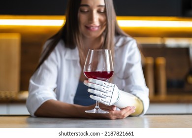 Calm Thoughtful Girl Holds Glass Of Wine In Bionic Arm At Home, Woman With Artificial Prosthetic Limb