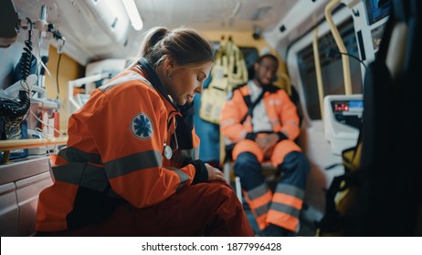 Calm and Tired Female EMS Professional Paramedic Mentally Prepares in Ambulance Vehicle on the Way to a Call. Emergency Medical Technicians are on Their Way to a Call Outside the Healthcare Hospital.