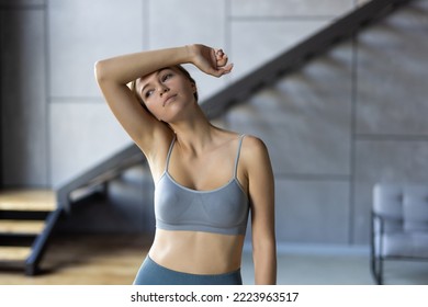 Calm Tired Fitness Woman In Tracksuit Doing Yoga Exercises Using Towel Sit On Mat Floor At Home. Workout Concept