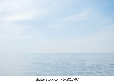 Calm tranquil blue sea with no waves and with foggy backgroudn